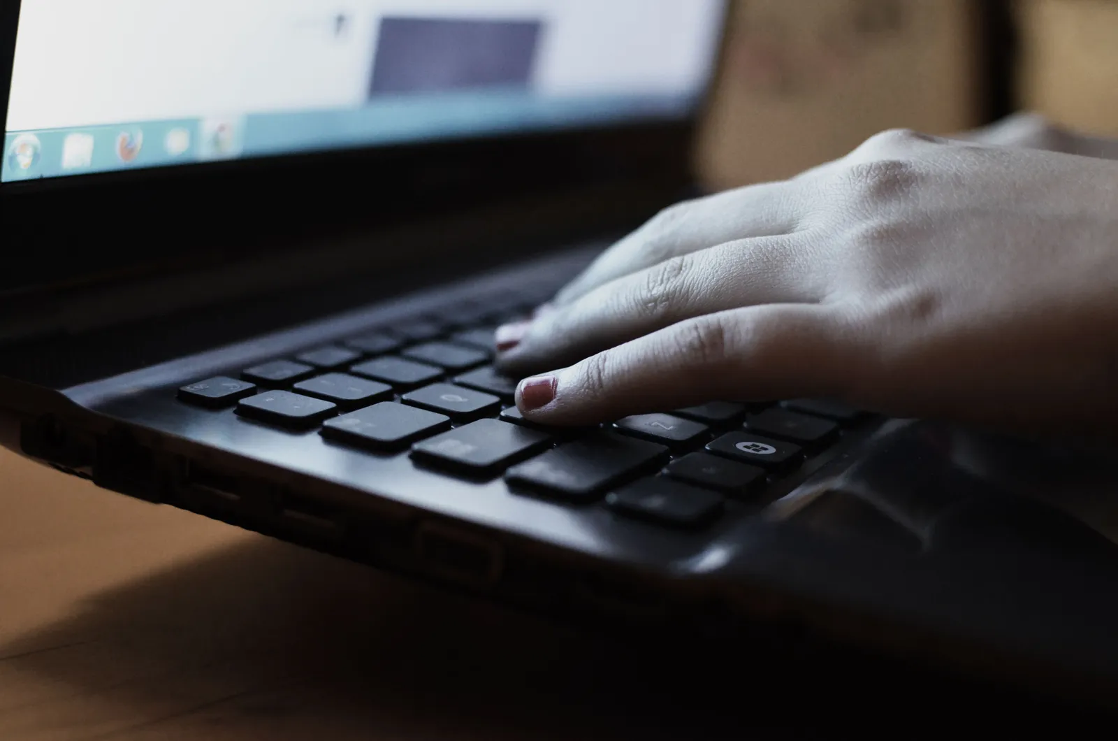 Hände auf einer schwarzen Laptoptastatur